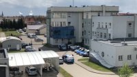 Zdjęcie kolorowe. Widok Komendy Powiatowej Policji w Szczecinku z lotu ptaka. Na zdjęciu poza budynkiem widać plac wewnętrzny jednostki.