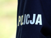 Zdjęcie kolorowe.Zbliżenie napisu policja umieszczonym na mundurze