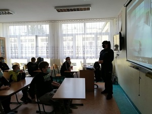 Zdjęcie kolorowe. Policjantka prowadzi spotkanie z uczniami w klasie