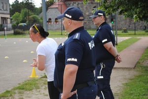 Zdjęcie kolorowe. Policjanci i uczniowie podczas egzaminu na kartę rowerową