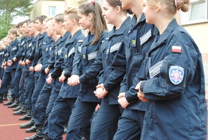 Zdjęcie kolorowe. Uczniowie ćwiczą policyjną musztrę.
