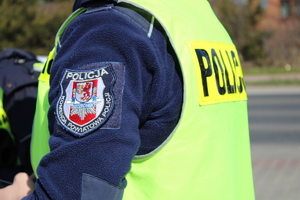 Zdjęcie kolorowe. Zbliżenie naszywki umieszczonej na rękawie kurtki policjanta
