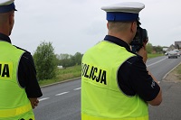 Zdjęcie kolorowe. policjanci ruchu drogowego dokonują pomiaru prędkości