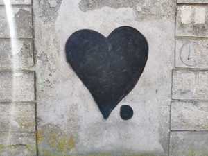 Zdjęcie kolorowe. Czarne serce namalowane na murze