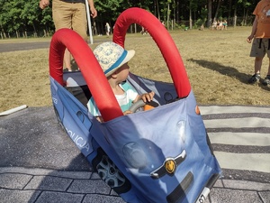 Zdjęcie kolorowe.  Dziecko siedzi w autochodziku