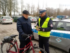 Policjant rozmawia z zatrzymanym do kontroli rowerzystą