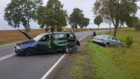 Zdjęcie kolorowe. Na prawym pasie widać zielonego, uszkodzonego opla w oddali na poboczu uszkodzony srebrny  pojazd marki Audi