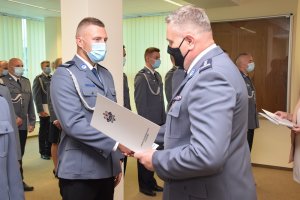 Zdjęcie kolorowe. Komendant Powiatowy wręcza akty mianowania szczecineckim policjantom.