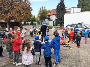 Zdjęcie kolorowe. Policjantka prowadzi zajęcia z przedszkolakami z wykorzystaniem piankowego miasteczka ruchu drogowego