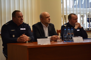 Zdjęcie kolorowe. Od lewej strony przy stole siedzi Zastępca Komendanta Powiatowego Policji w Szczecinku, Starosta oraz Komendant Wojewódzki Policji w Szczecinie