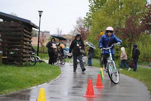 Zdjęcie kolorowe. Uczestnicy na rowerach pokonują slalom.