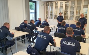 Zdjęcie kolorowe. Policjanci podczas pisania testu z wiedzy ogólnej