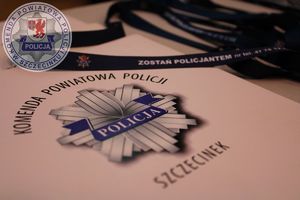 Zdjęcie kolorowe. Ekspozycja teczki z logo szczecineckiej policji