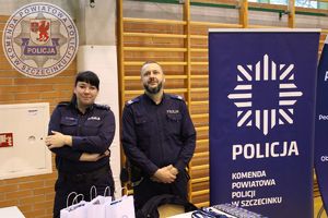 Zdjęcie kolorowe. Policjanci stojący przy swoim stoisku