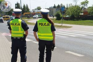 Zdjęcie kolorowe. Policjanci prowadzą obserwacje w pobliżu przejść dla pieszych