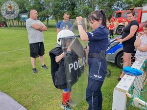 Zdjęcie kolorowe. Policjantka prezentuje strój podwyższonego ryzyka