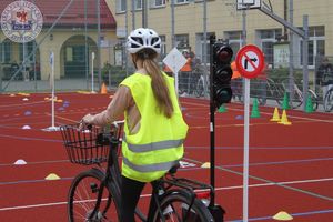 Zdjęcie kolorowe. Uczeń na rowerze podczas egzaminu