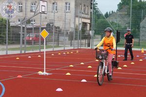 Zdjęcie kolorowe. Uczeń na rowerze podczas egzaminu