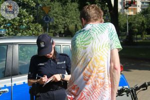 Zdjęcie kolorowe. Policjantka legitymuje rowerzystów