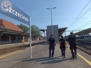 Zdjęcie kolorowe. Policjant wspólnie z patrolem sok patrolują perony kolejowe