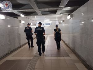 Zdjęcie kolorowe. Policjant wspólnie z patrolem sok patrolują perony kolejowe