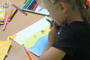 Zdjęcie kolorowe. Dziecko rysuje swoją prace plastyczną