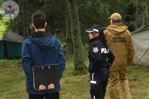 Zdjęcie kolorowe. Policjantka strażacy i przedstawiciel gminy podczas kontroli