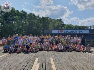 Zdjęcie kolorowe. Grupowe zdjęcie półkolonistów na tle grafiki w języku angielskim &quot;i love szczecinek&quot;