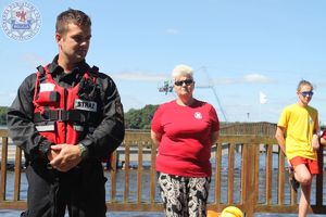 Zdjęcie kolorowe. Na pomoście stoją przedstawiciele służb. Sanepidu WOPRu, straży i policji