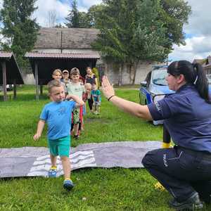 Zdjęcie kolorowe. Spotkanie policjantki z dziećmi