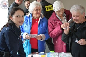 Zdjęcie kolorowe. Policjantka w towarzystwie seniorek