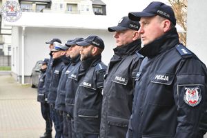 Zdjęcie kolorowe. Policjanci ustawieni w szeregu