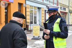 Zdjęcie kolorowe. Policjanci wręczają odblaski