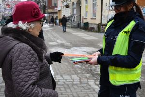 Zdjęcie kolorowe. Policjanci wręczają odblaski