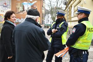 Zdjęcie kolorowe. Policjanci wręczają odblaski