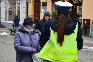 Zdjęcie kolorowe. Policjanci wręczają odblaski