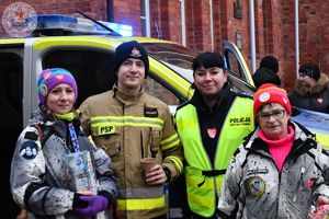 Zdjęcie kolorowe. Zdjęcie policjanta z wolontariuszami