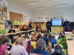 Zdjęcie kolorowe. Dzielnicowi na spotkaniu z uczniami