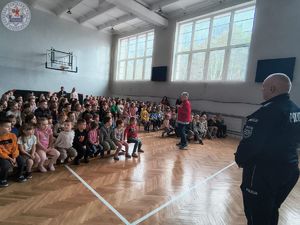 Zdjęcie kolorowe. Dzielnicowi na spotkaniu z uczniami