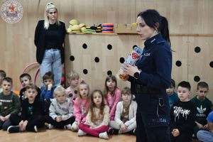 Zdjęcie kolorowe. Policjantka na spotkaniu z uczniami