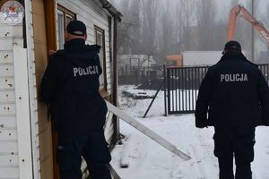 Zdjęcie kolorowe. Policjanci kontrolują pustostany