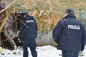 Zdjęcie kolorowe. Policjanci kontrolują pustostany