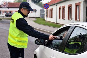 Zdjęcie kolorowe. Policjanci kontrolują pojazdy i stan trzeźwości kierujących