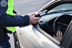 Zdjęcie kolorowe. Policjanci kontrolują pojazdy i stan trzeźwości kierujących