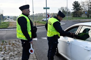 Zdjęcie kolorowe. Policjanci kontrolują pojazdy i stan trzeźwości kierujących