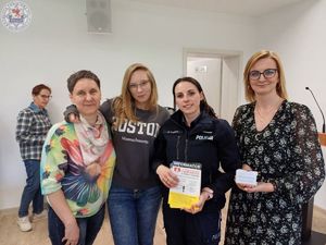Zdjęcie kolorowe. Policjantka pozuje do wspólnego zdjęcia z 3 innymi kobietami