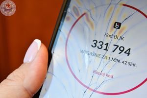 Zdjęcie kolorowe. Telefon z wyświetlonym cyfrowym kodem BLIK