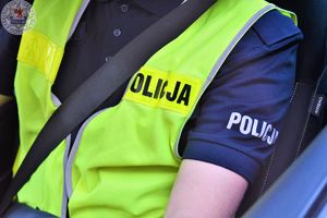 Zdjęcie kolorowe. Zbliżenie pasów bezpieczeństwa zapiętych przez policjanta