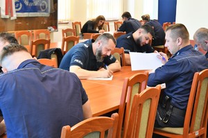 Zdjęcie kolorowe. Policjanci piszą test