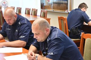 Zdjęcie kolorowe. Policjanci piszą test